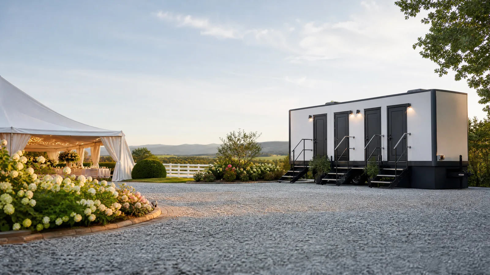 Luxury portable restroom trailer positioned discreetly at an outdoor wedding venue.